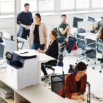 Eine Gruppe von Fachleuten, die in einem Büro zusammenarbeiten, Computer und den Xerox® VersaLink® B625 Multifunktionsdrucker für ihre Aufgaben nutzen. Eine Gruppe von Fachleuten, die in einem Büro zusammenarbeiten, Computer und den Xerox® VersaLink® B625 Multifunktionsdrucker für ihre Aufgaben nutzen.