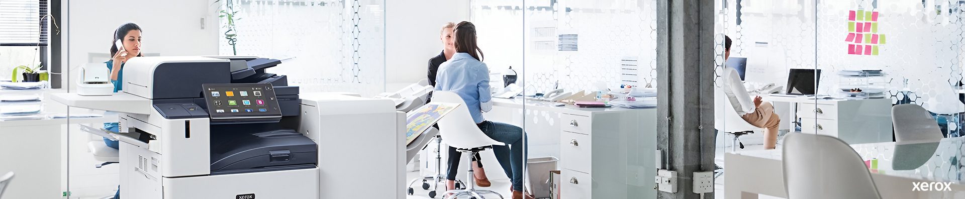 Ein geräumiges Büro mit einem Xerox®-Drucker und einem Computer auf einem Schreibtisch, das eine professionelle Arbeitsumgebung darstellt.