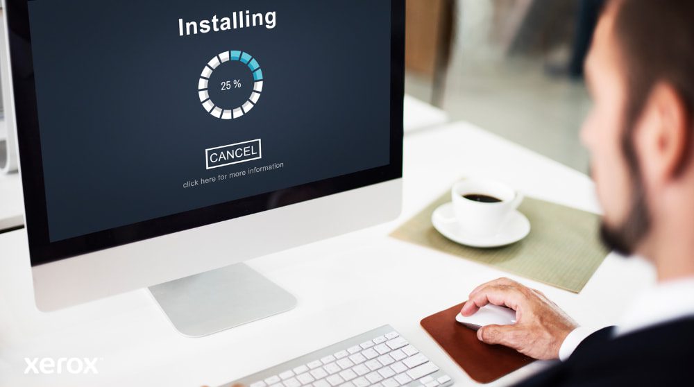 Eine Nahaufnahme eines Computermonitors mit einem Fortschrittsbalken „Installation läuft“ bei 25 %, mit der Hand einer Person auf einer Computermaus neben einer Kaffeetasse, was die einfache Einrichtung der Software veranschaulicht.